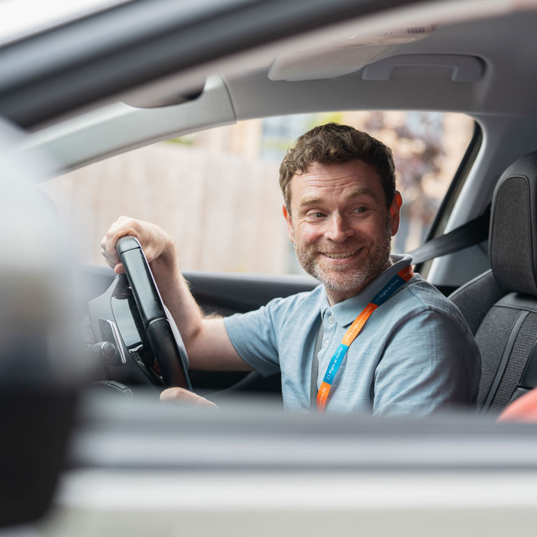 Client and Carer smiling while in car