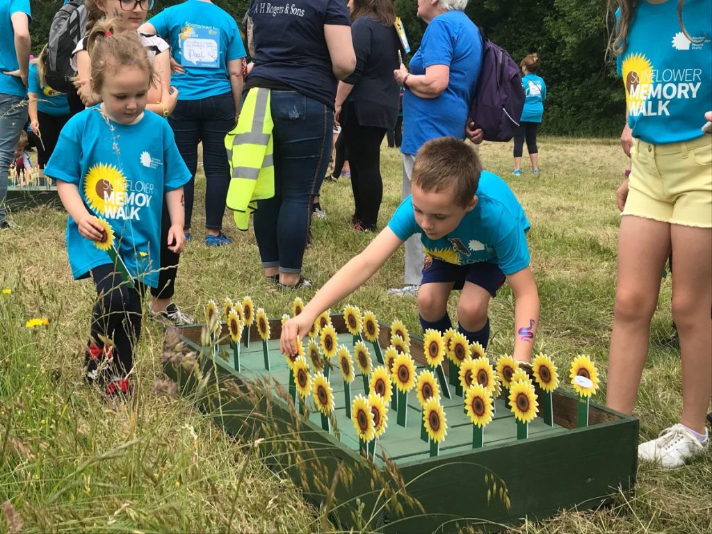 Young children Playing Outside with Sunflowers for Mountbatten Hampshire