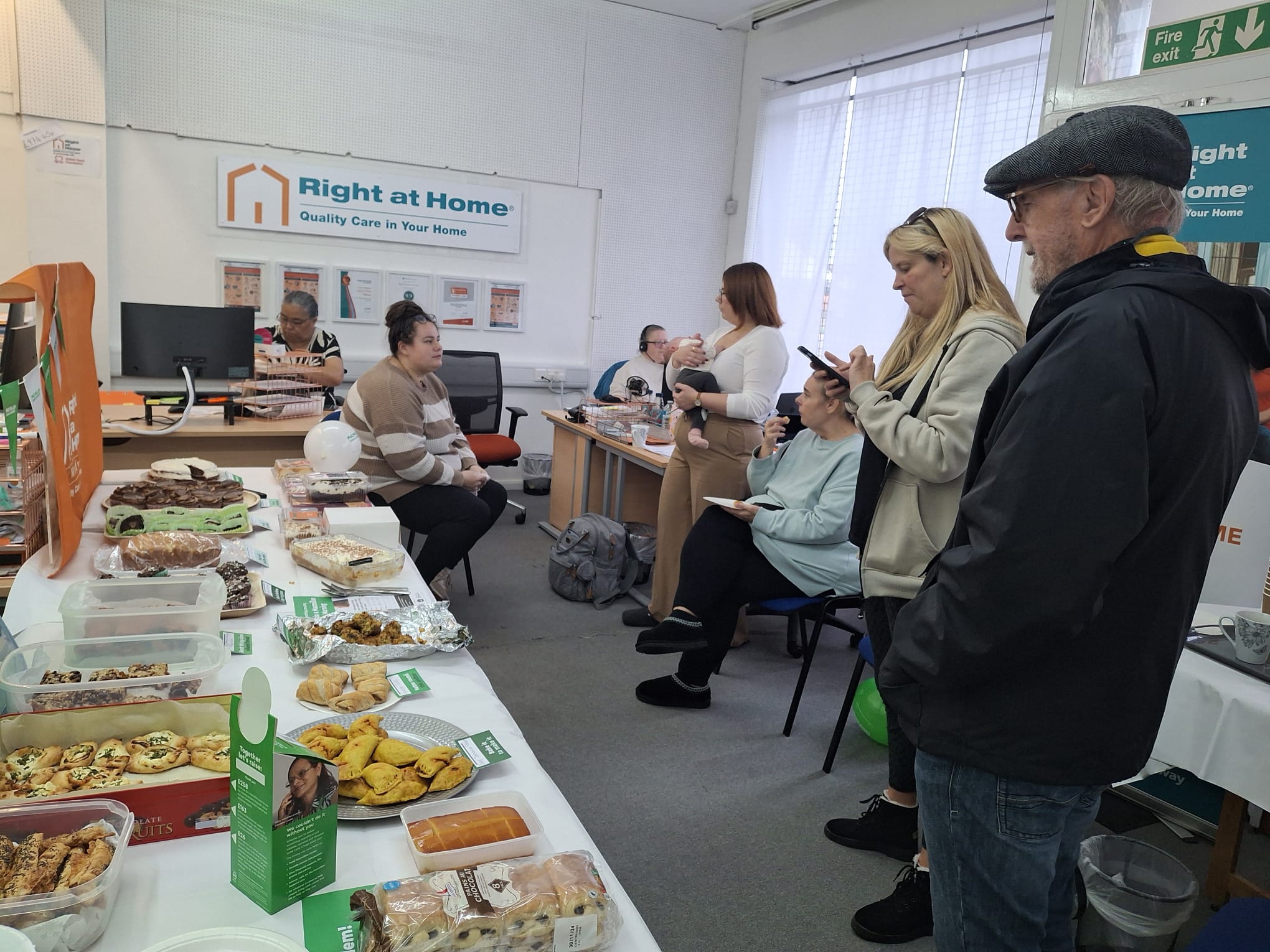 Open coffee morning picture of the table of food, some client's families and some of our staff