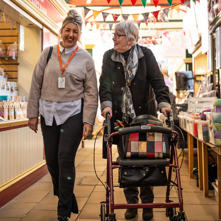 Client and Carer walking through market during visit