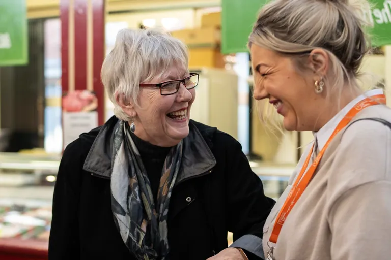Carer accompanying an older client around a market