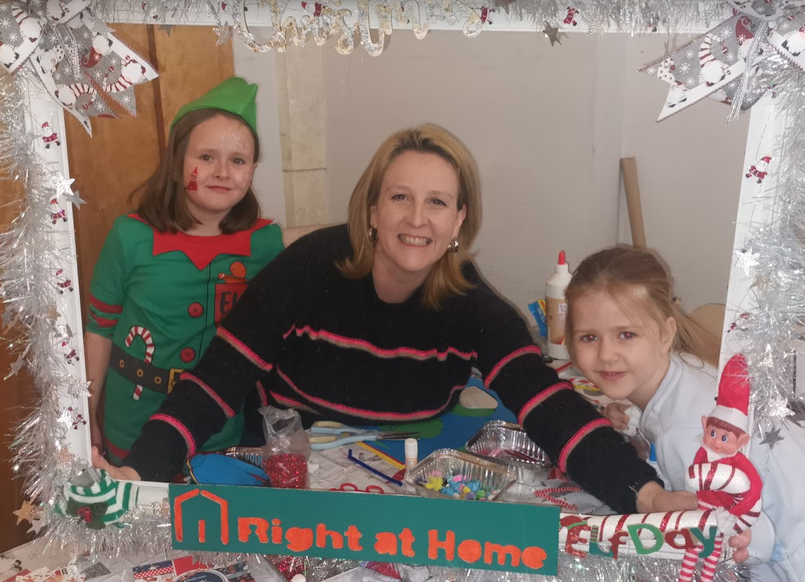 Two young girls and a woman pose in a selfie frame