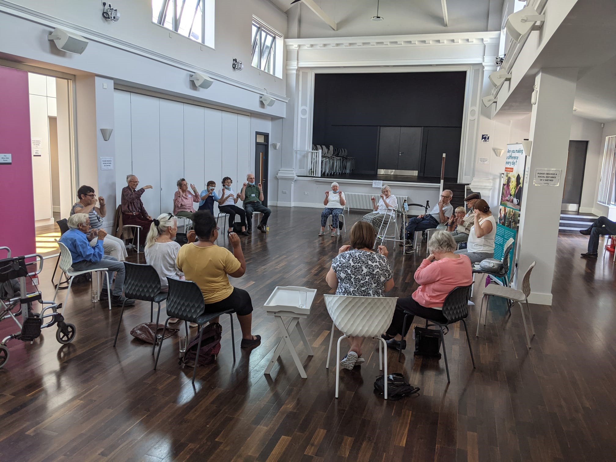 Group of people sitting in a circle exercising.