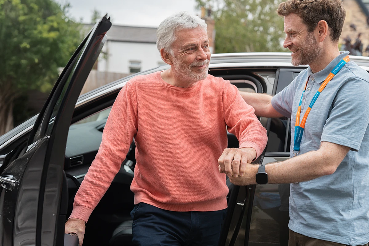 Client being supported by their Carer out of the car following a day trip