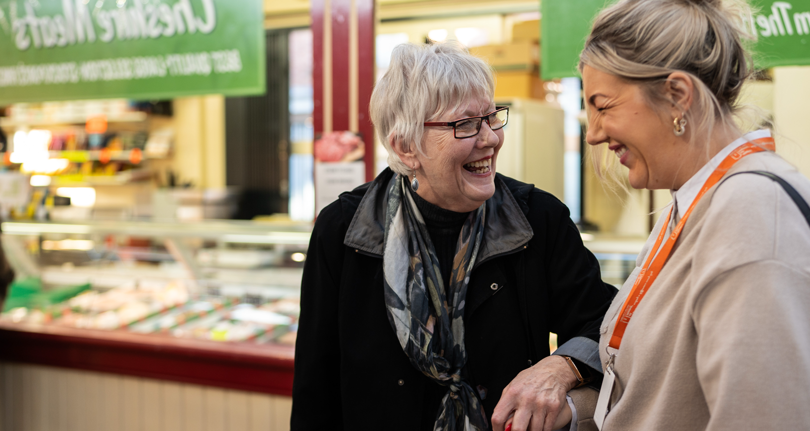 Carer accompanying an older client around a market