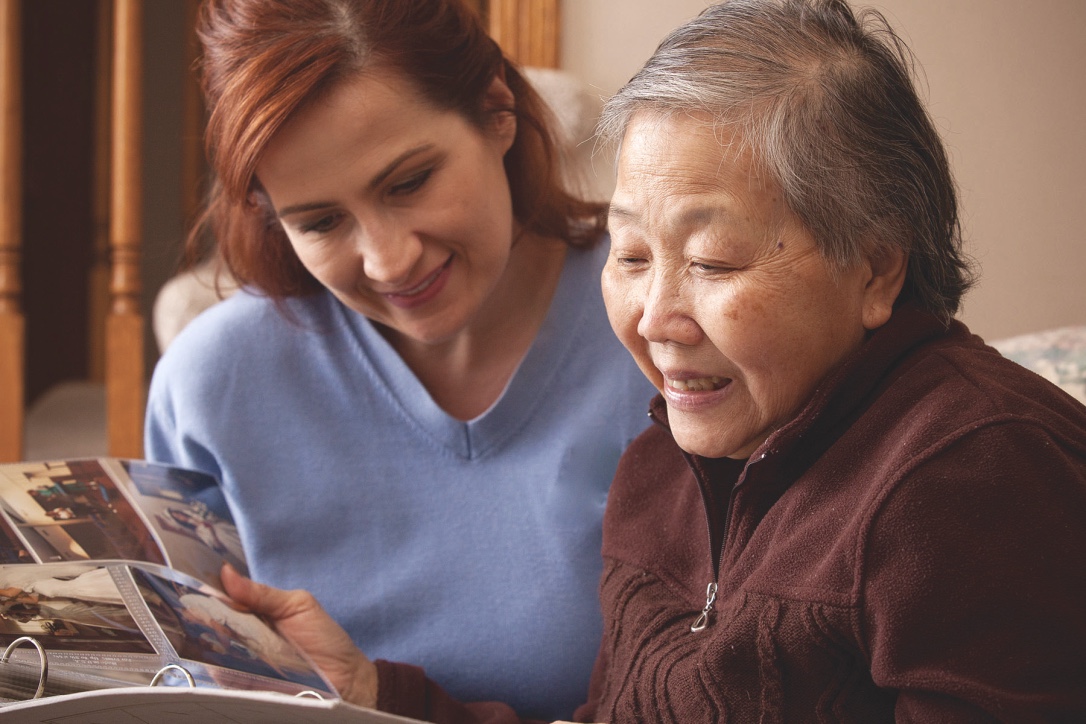 Caregiver looking through at photographs with a client