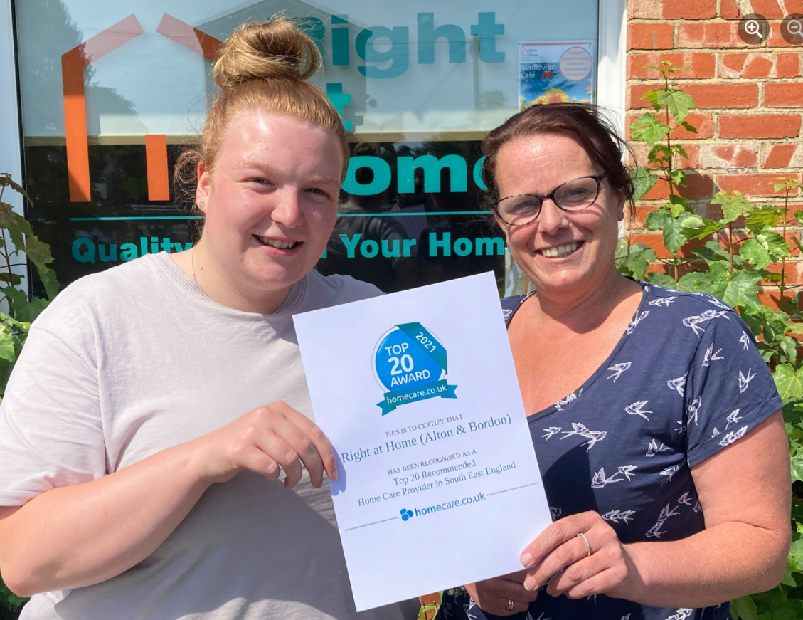 Two smiling females holding a certificate.