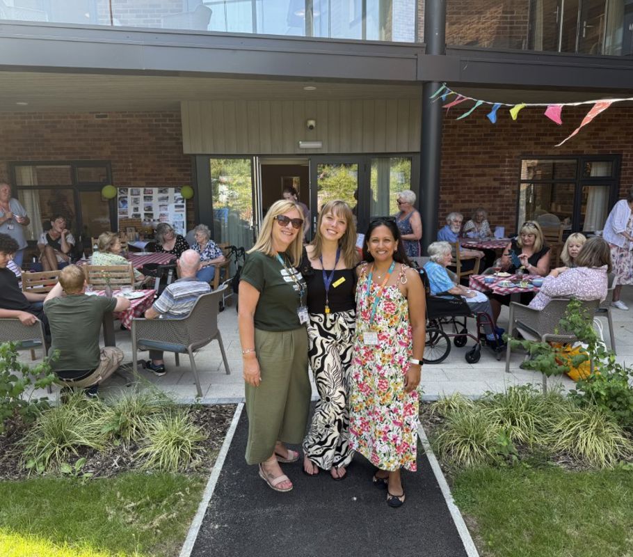 Right at Home Solent director with staff at the Big Green Picnic event, with clients and team members in the background.