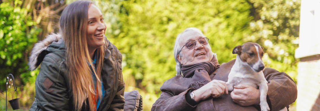 Woman and elderly gentleman sitting on a bench talking