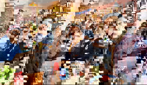 Care workers smile sat around a table at a team meeting