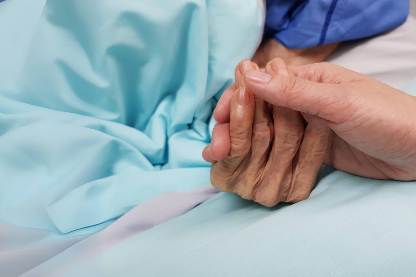 lady-holding-the-hand-of-an-older-lady-receiving-compassionate-end-of-life-care-at-home-in-cheshire-east