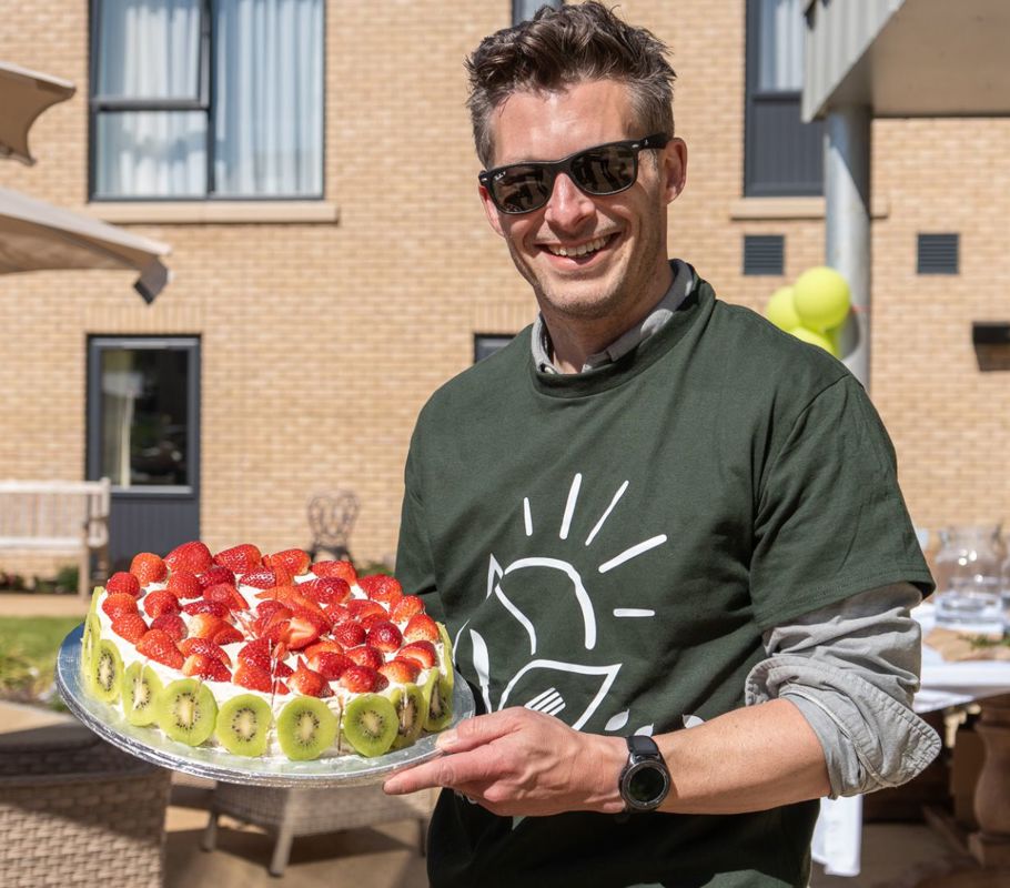 chris holding cake at big green picnic